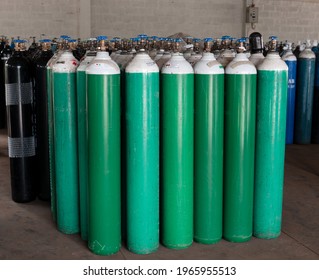 Many oxygen cylinders and argon cylinders with compressed gas secured in the Gas factory warehouse. Green Oxygen tanks for hospital. Black Oxygen tanks for industry. Blue argon tanks for industry.