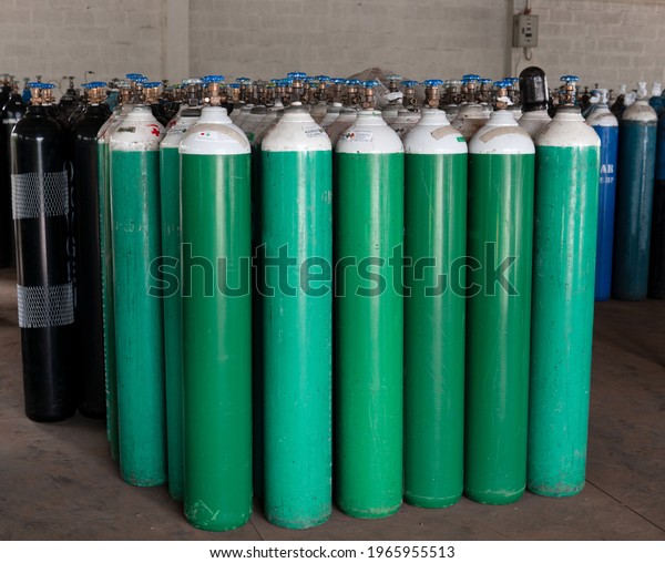 Many oxygen cylinders and argon cylinders with\
compressed gas secured in the Gas factory warehouse. Green Oxygen\
tanks for hospital. Black Oxygen tanks for industry. Blue argon\
tanks for industry.