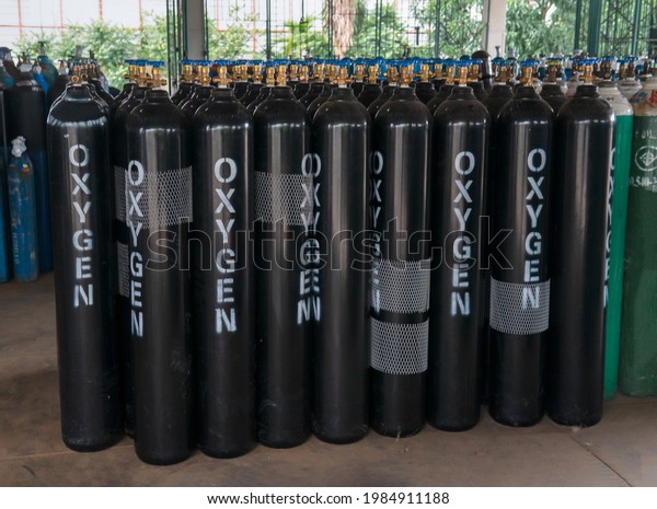 Many oxygen\
cylinders with compressed gas secured in the factory warehouse.\
Black Oxygen tanks for industry.\
