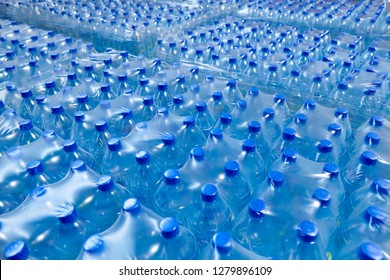 Many Packaged Blue Mineral Water Bottles In Stock In A Store Or Market.