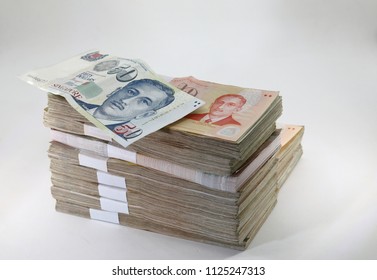 Many Packs Of Singapore Dollar Bills, Stacks Of Banknotes, Pile Of Cash, Paper Money. The Concept Of Financial Success, Investment And Wealth. Isolate On White Background.