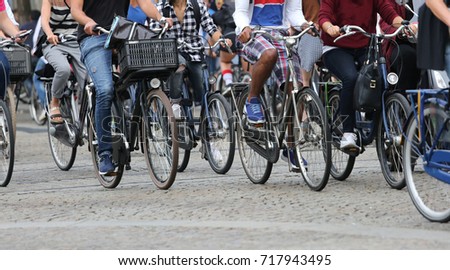 many people fast riding bicycles in Amsterdam in the Netherlands