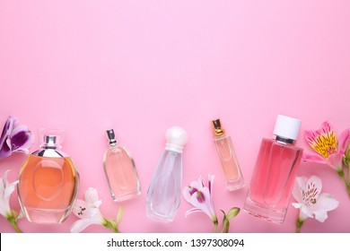 Many perfume bottles on a pink background, top view