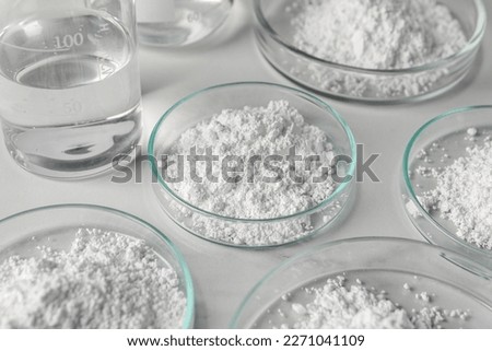 Many petri dishes with calcium carbonate powder on white background