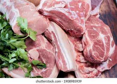 Many pieces of fresh pork meat on a wooden cutting board