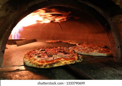 many pizzas inside an oven in the italian pizzeria