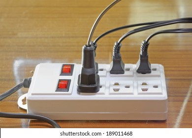 Many Plugs Plugged Into Electric Power Bar.