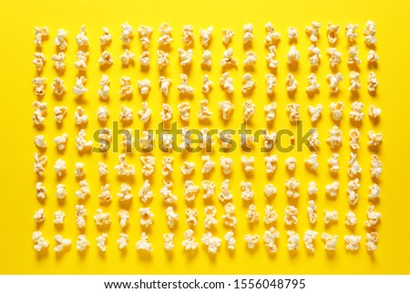 Many popcorn and one kernel on color background. Concept of uniqueness