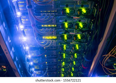Many powerful computer servers work in the dark room of the data center. Rack with hosting resources of a large Internet provider. Information technology concept