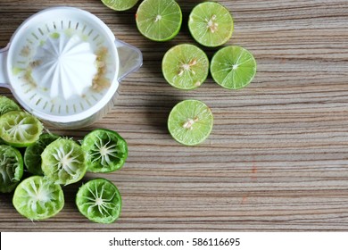 Many preparation of limes juice squeezed and a manual juicer on wooden table