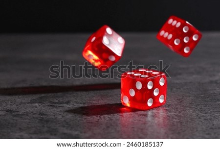 Many red game dices falling on grey textured table