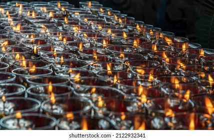 Many red votive candles light inside Chinese temple. Rows of Votive Candles in Glass with shallow depth of field, Red Candle is kindle a fire in glass, Abstract Meaning of Religion. Selective Focus.