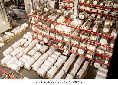 Many rolled polyethylene film units on shelves and racks inside warehouse