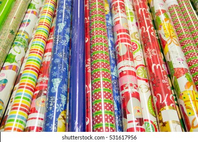 Many Rolls Of Various Different Colored, Patterned, Printed, Wrapping Paper For Packaging, Decorating, Enfoldment, Ornaments Gifts Are At The Store For Sale. Christmas Theme. Close-up