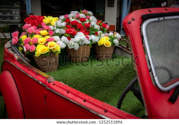 Many roses in a basket on a\
car.