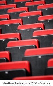 Many rows of empty seats in a stadium waiting for fans, ideal for high-quality creative concepts, including seating, arena, red, black.