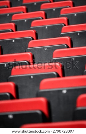 Many rows of empty seats in a stadium waiting for fans, ideal for high-quality creative concepts, including seating, arena, red, black.