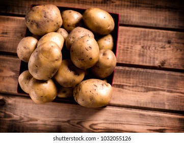 Many Russet Potatoes In Crate On Table