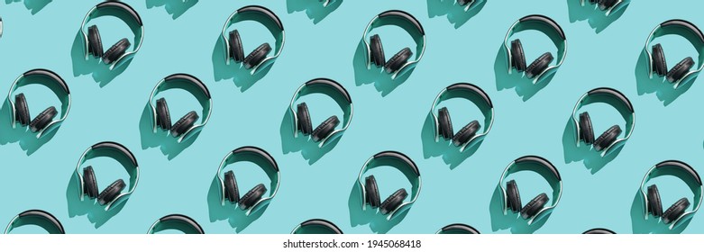 Many Same Headphones On Blue Bright Background. Modern Music Concept. Top View Repeat Layout. Headset Trend Wallpaper. Flatlay. Technology Hipster Accessory
