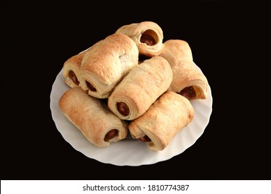 Many Sausage Rolls (pigs In A Blanket) On White Plate On Black Table