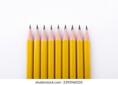 Many sharp graphite pencils on white background, top view