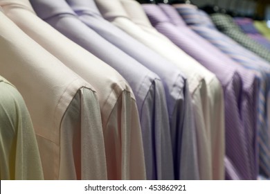 Many shirts hanging on a rack