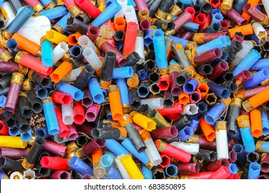 Many Shotgun Shells Of Various Colors, Background Texture Pattern With Empty Fired Cartridges.