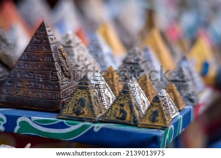Many small colorful pyramid souvenirs for sale on the streets of cairo, egypt. Salesman looking to earn money and haggle with tourists, stone, limestone and alabaster figurines for sale