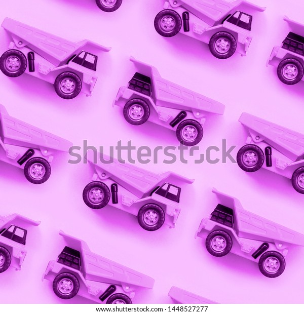 Many small purple toy trucks on\
texture background of fashion pastel purple color\
paper
