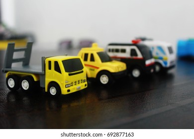 Many Small Toy Cars Lined Up On The Wooden Background