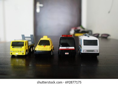 Many Small Toy Cars Lined Up On The Wooden Background