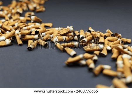 Many smoked cigarettes on a gray background. Smoking can be harmful to your health. Passion for cigarettes. Scattered butts, brown filter. Depression, health problems