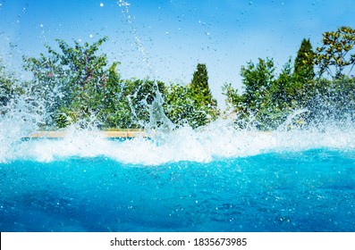 Many splashes in the swimming pool after jump diving over garden on sunny day - Powered by Shutterstock