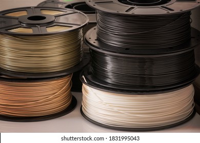 Many spools of 3D printer plastic filaments.