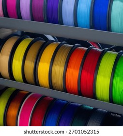 Many spools with multi-colored plastic for 3D printing. Spools with yellow, orange, brown, red green plastic wire for 3D printer. Components for 3D printing. Accessories for 3D printer. FDM technology