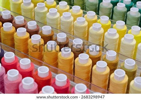 Many spools of thread of different colors, close up shot, abstract textile industry background
