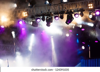 Many Spotlights That Illuminate The Stage At A Concert With Fog