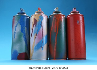 Many spray paint cans on light blue background, low angle view - Powered by Shutterstock