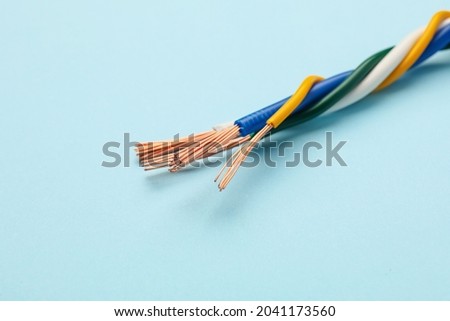 Many stripped electrical wires on light blue background, closeup