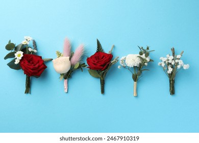 Many stylish boutonnieres on light blue background, flat lay - Powered by Shutterstock