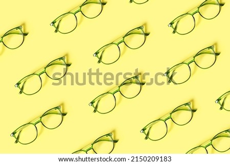 Many stylish eyeglasses on yellow background. Pattern for design