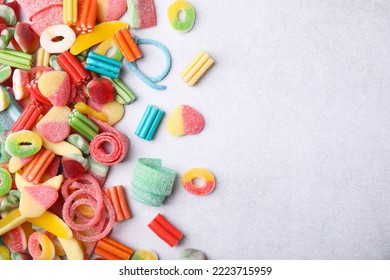 Many Tasty Colorful Jelly Candies On White Table, Flat Lay. Space For Text