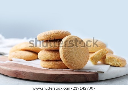 Many tasty sugar cookies on wooden board