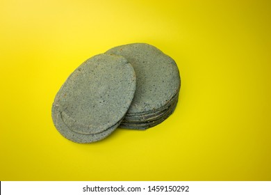 
many tortillas made of blue corn on yellow background