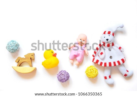 Many toys for children's games on a white background. Rocking wooden horse, yellow rubber duck, doll and teddy bear. Mockup, free space for text