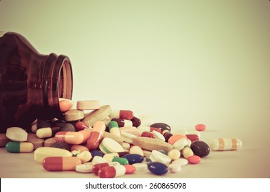 Many type of medical drugs pills capsules and medicine poring from the bottle with  isolation background in vintage retro color. Used for manufacturing health industry concept. - Shutterstock ID 260865098