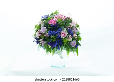 Many types of beautiful, bright flowers arranged in a clear vase.