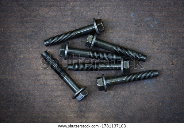 Many used bolts\
with lubricant oil on a\
paper
