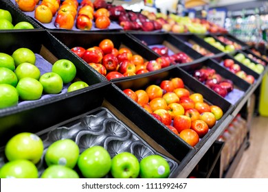 Many Varieties Assorted Red Apples On Display Shelf In Grocery Store Boxes In Aisle, Supermarket Inside, Nobody