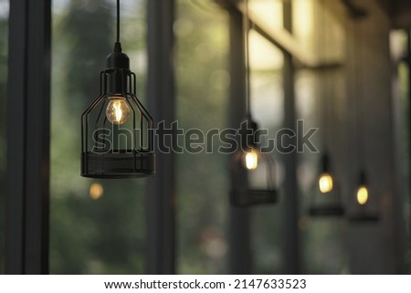 many vintage styles hanged ceiling lamp warm orange tone light color bulb light with blurred glass wall background